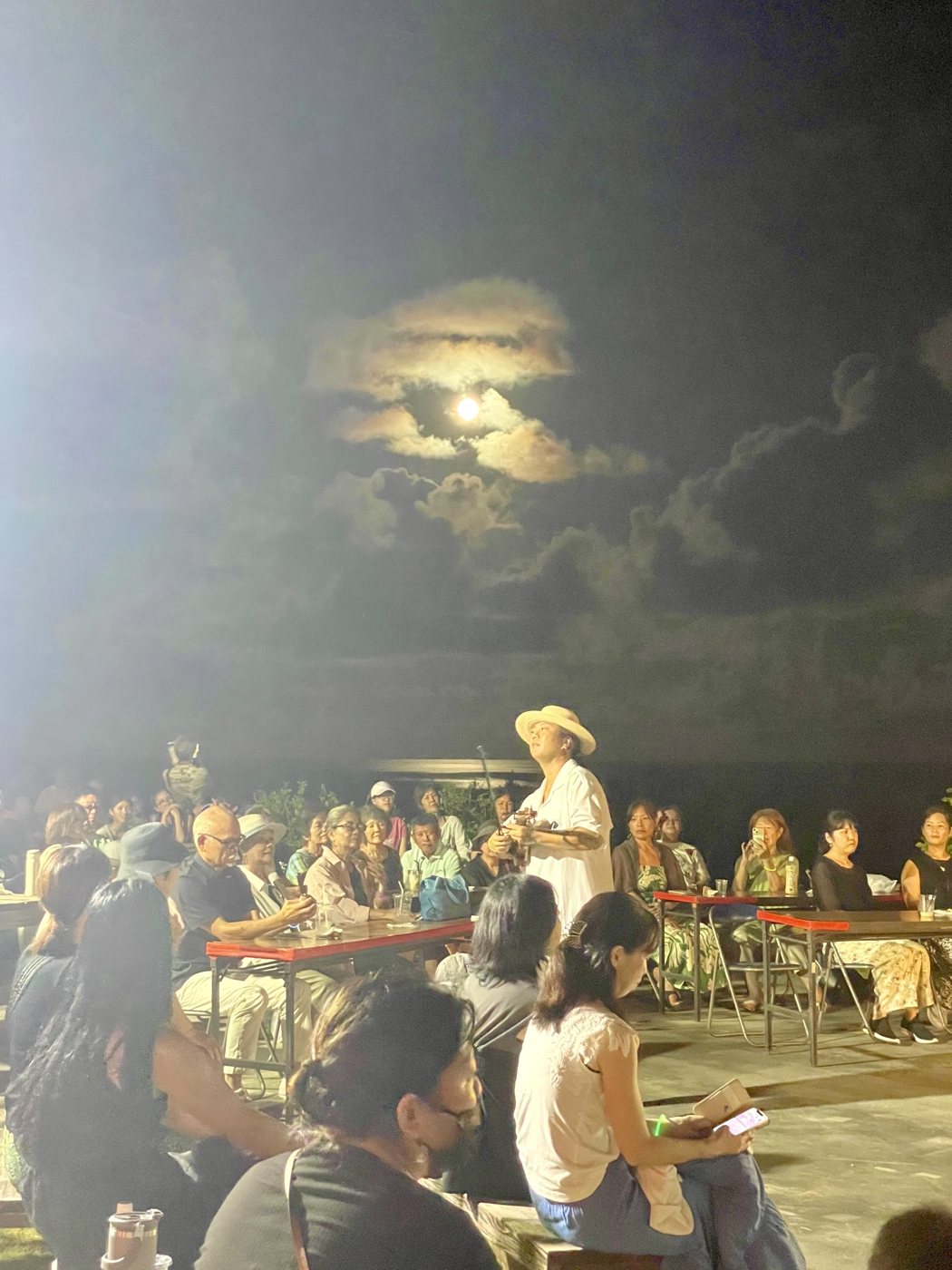 雲間の月あかりの下、演奏に耳を傾ける会場